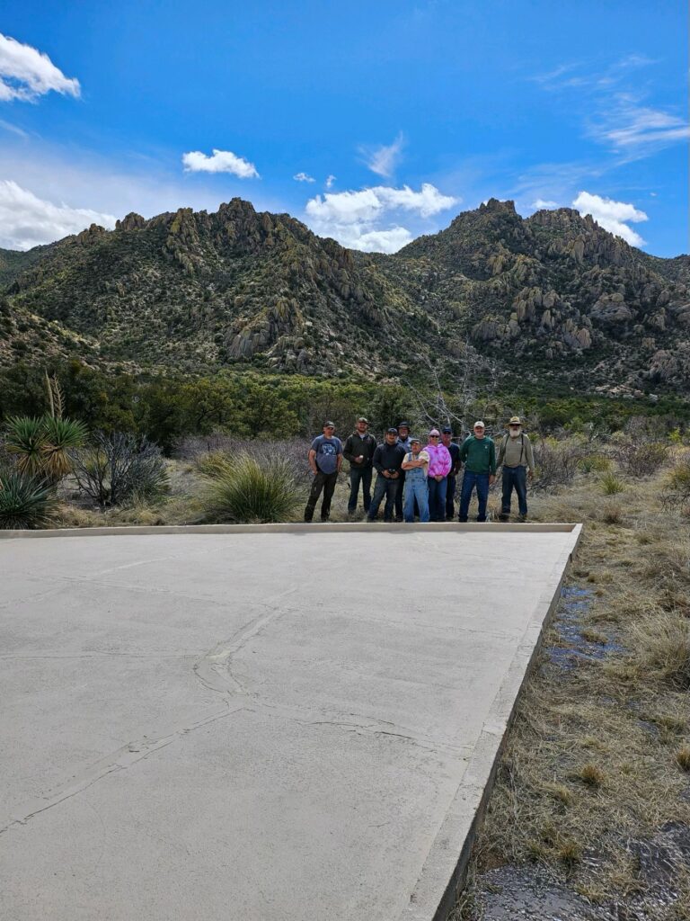 Group of successful people posing for a photo with a rugged mountainous backdrop in Southern Arizona.